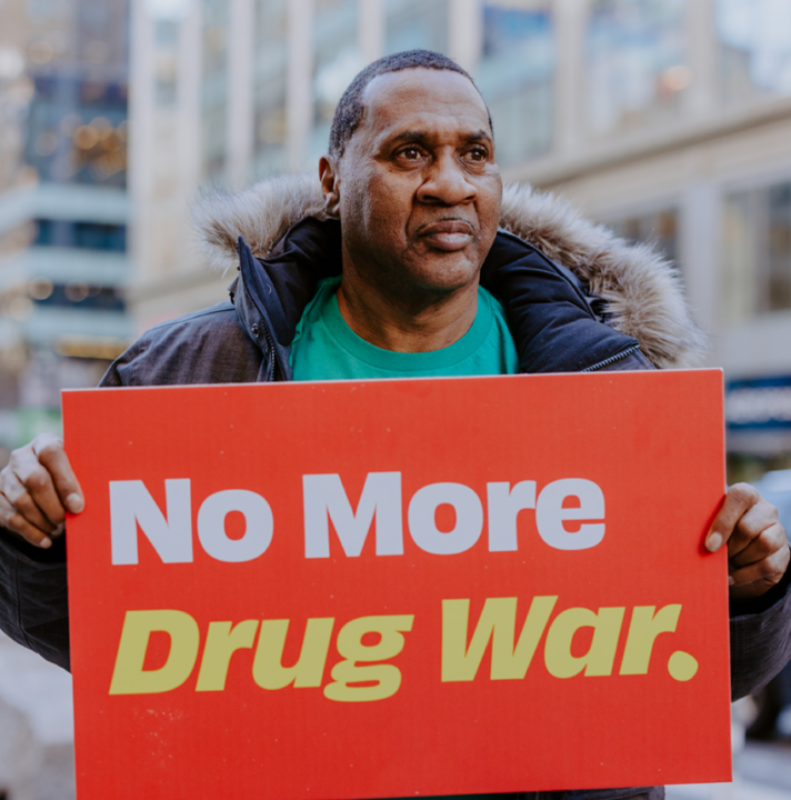 Man holding a "No More Drug War" sign.